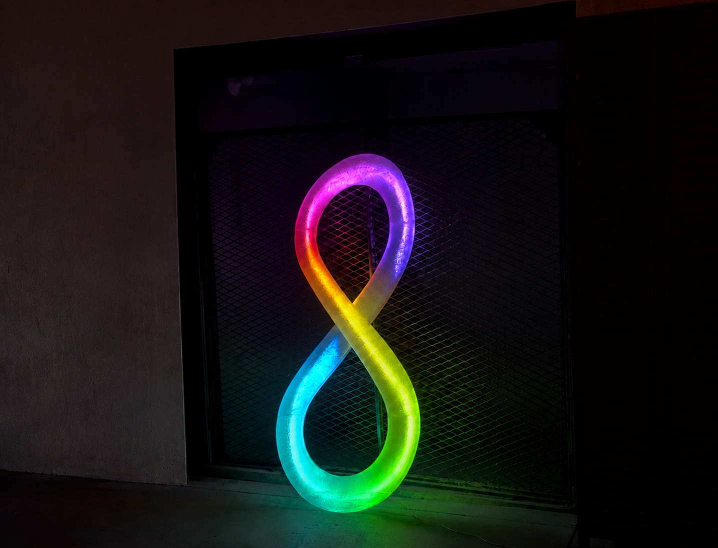 3D-printed RGB-lit infinity sculpture glowing in rainbow colors — custom illuminated signage